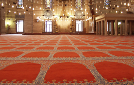 When should one stand up during the Iqamah?